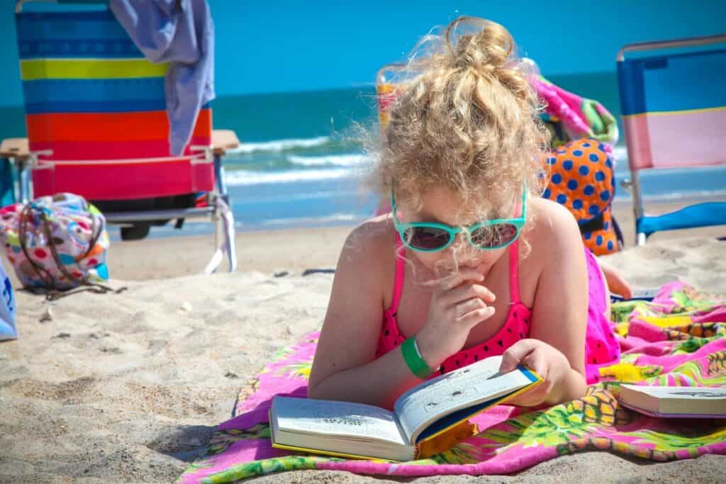 Girl at the beach reading a book