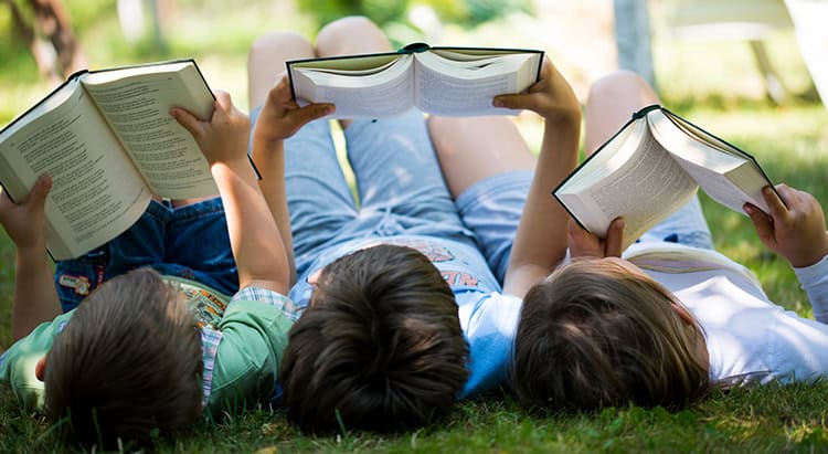 Three children reading in the garden